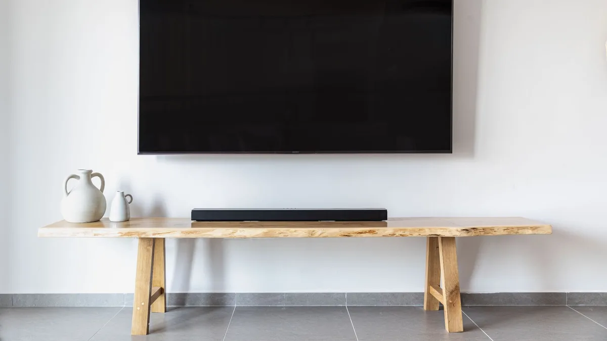 Stylish minimalist living room featuring a wall-mounted flat screen TV and wooden console.
