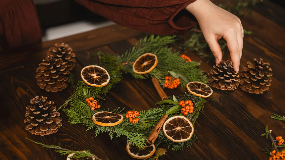 Create a festive wreath with pinecones, dried oranges, and berries for Christmas decor.