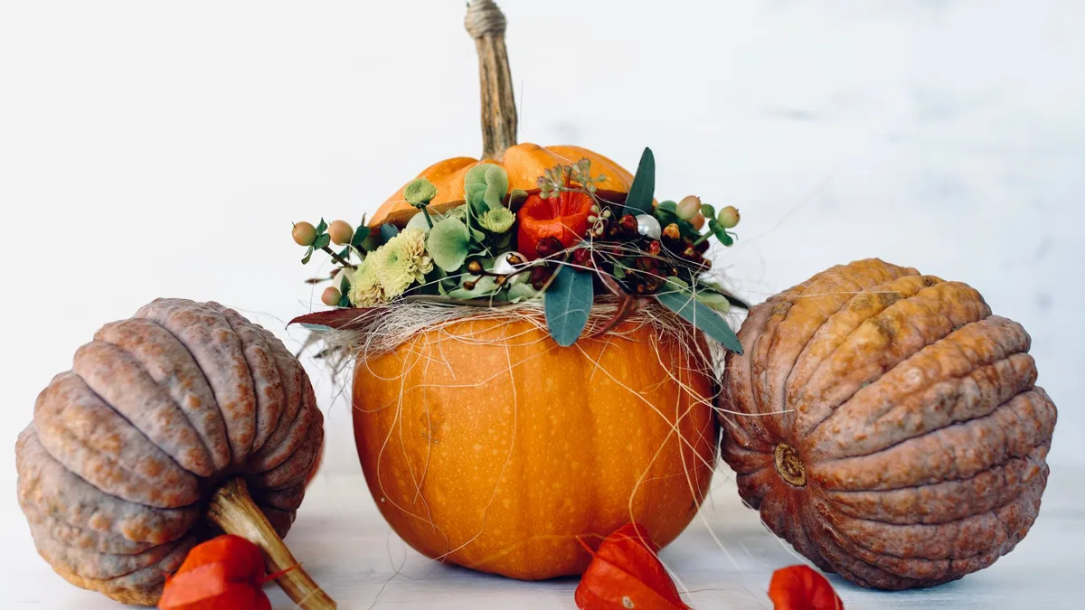 Beautiful decorative arrangement of pumpkins and gourds with vibrant fall foliage capturing the essence of autumn.