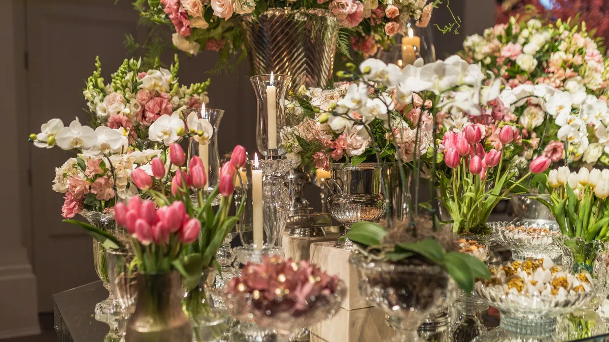 Beautifully arranged pink and white flowers with candles on a decorative table setting.