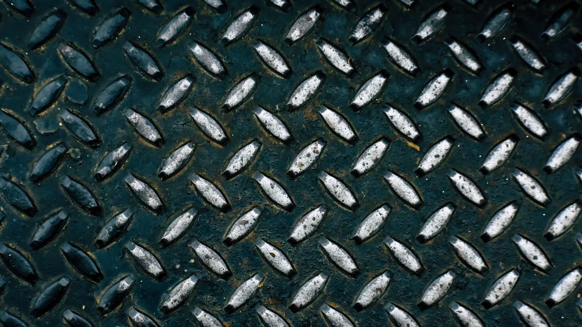 Detailed view of a diamond plate metal surface showcasing its rugged pattern.