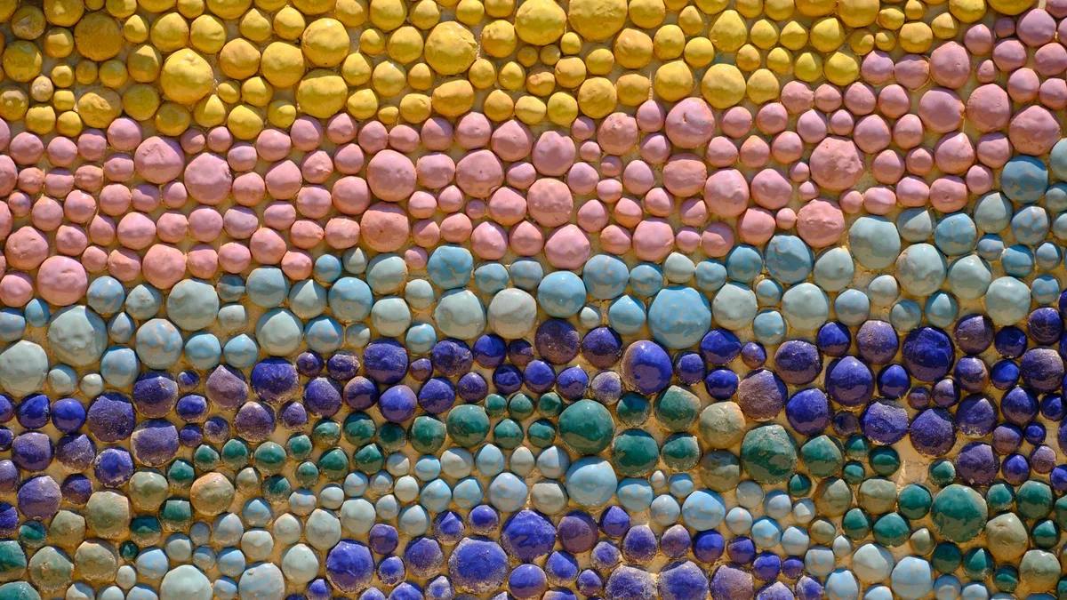 Vibrant mosaic wall art featuring colorful, textured pebbles arranged in a decorative pattern.